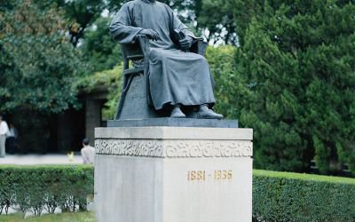 公園廣場大型景觀坐著石柱上面的玻璃鋼魯迅雕塑